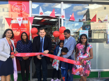 Louie cutting ribbon to open new Post Office